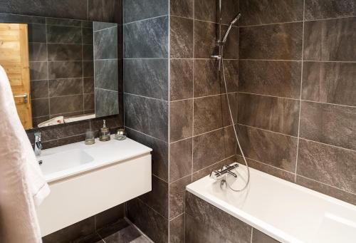 a bathroom with a sink and a tub and a toilet at Residence Lesporting Ski – Appartment – АЕ103 in Megève