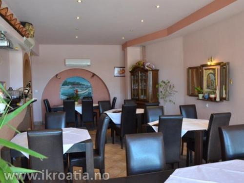 un comedor con mesas y sillas en un restaurante en Guest house Garfild 2 en Novi Vinodolski