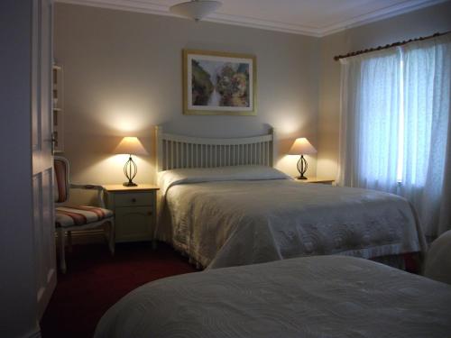ドゥーリンにあるRiverdale Farmhouseのベッド2台と窓が備わるホテルルームです。