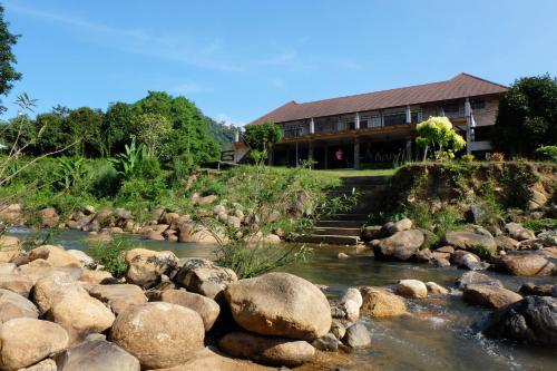 a river with rocks in front of a house at Akantuka Homestay in Chanthaburi