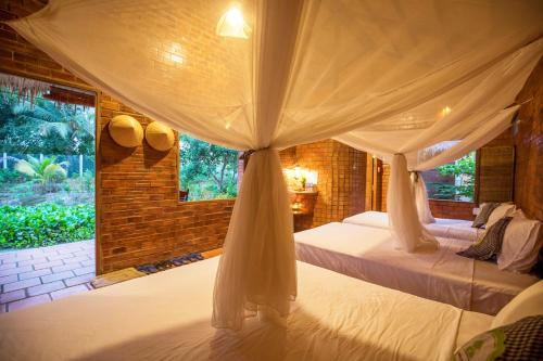 a bedroom with a bed with a canopy at Mekong Rustic Cai Be in Cai Be