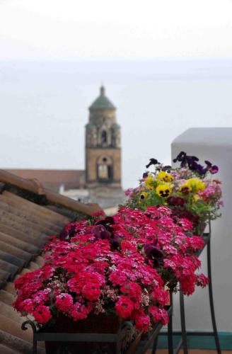 a bunch of flowers in front of a clock tower at Hotel Villa Annalara charme and Relax in Amalfi