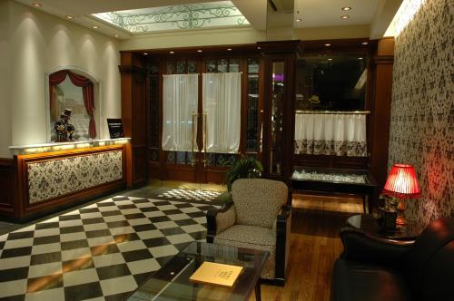 a lobby with a chair and a table and a mirror at Tanguero Hotel Boutique Antique in Buenos Aires