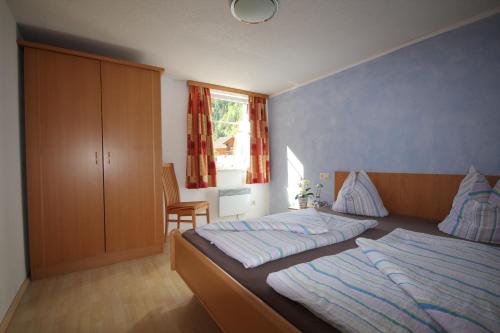 sypialnia z 2 łóżkami, szafką i oknem w obiekcie Appartementhaus Mentil w mieście Flattach