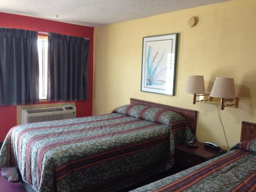 ein Hotelzimmer mit 2 Betten und einem Fenster in der Unterkunft De Leon Inn in De Leon
