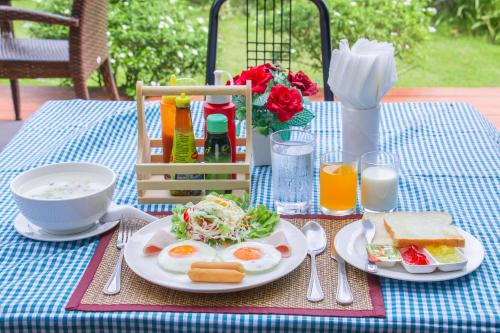a table with two plates of breakfast food on it at Akantuka Homestay in Chanthaburi