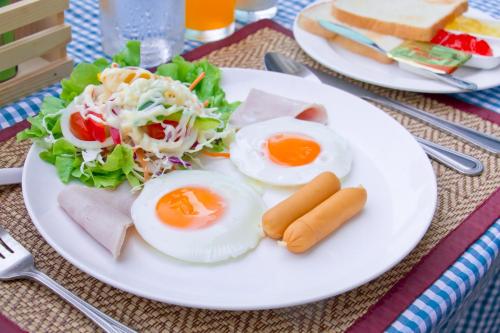 a plate of food with eggs and a salad at Akantuka Homestay in Chanthaburi