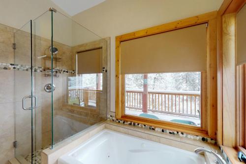 a bathroom with a bath tub and a window at Chipmunk Cabin in Green Mountain Falls