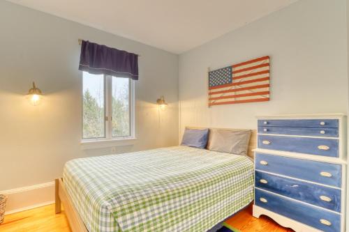 a bedroom with a bed and an american flag on the wall at Sea At Last in Phippsburg