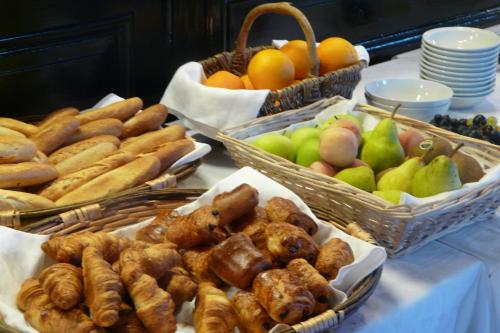 a buffet filled with different types of bread and fruit at Hostellerie d'Héloïse Logis in Cluny