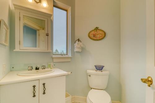 a bathroom with a toilet and a sink and a window at Sea At Last in Phippsburg