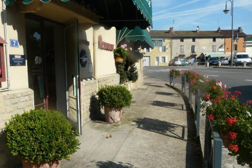 a sidewalk with potted plants next to a building at Hostellerie d'Héloïse Logis in Cluny