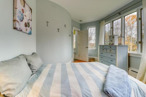 a bedroom with a bed and a dresser and windows at Sea At Last in Phippsburg