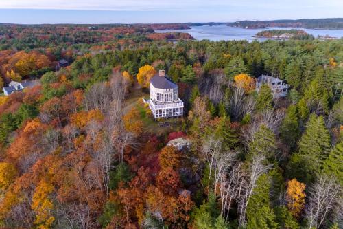 an aerial view of a house on a hill in the forest at Sea At Last in Phippsburg