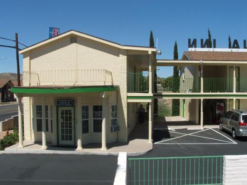 a building with a car parked in a parking lot at Arizona Inn in Kingman