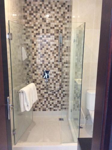 a shower with a glass door in a bathroom at PrimeBiz Tegal in Tegal