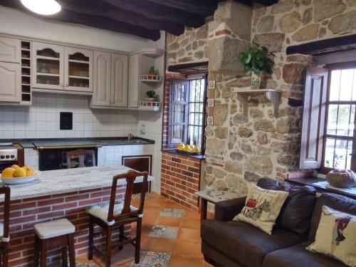 列加內斯的住宿－La Costera en Liérganes, Cabarceno，带沙发和石墙的厨房