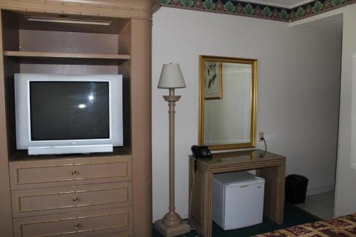 a bedroom with a tv on a dresser and a mirror at Best Whittier Inn in Whittier