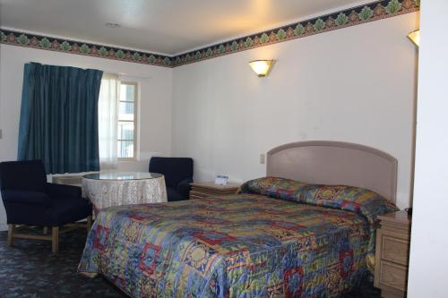 una camera d'albergo con letto, tavolo e finestra di Best Whittier Inn a Whittier