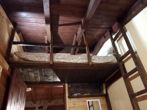 an attic room with a bed on the ceiling at Stone house on the rock in Lílaia