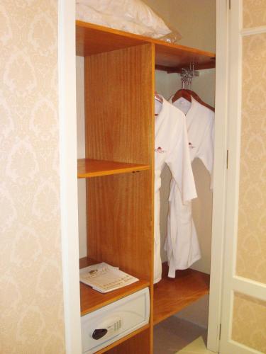 a closet with wooden shelves and white clothes at Tanguero Hotel Boutique Antique in Buenos Aires