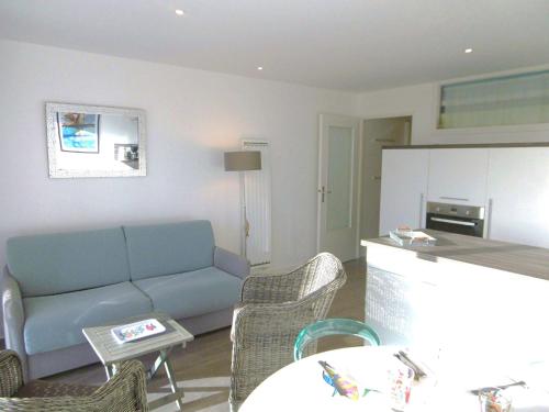 un salon avec un canapé et une cuisine dans l'établissement Appartement Iwan, à Sarzeau