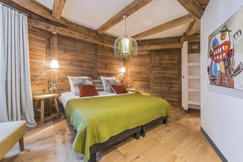 une chambre avec un lit dans une pièce aux murs en bois dans l'établissement Penthouse Le Savoie - LES CHALETS COVAREL, à Val dʼIsère