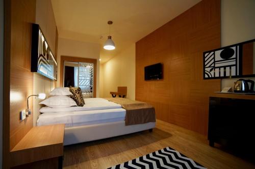a bedroom with a large bed and a television at Astoria Hotel & SPA in Hunedoara