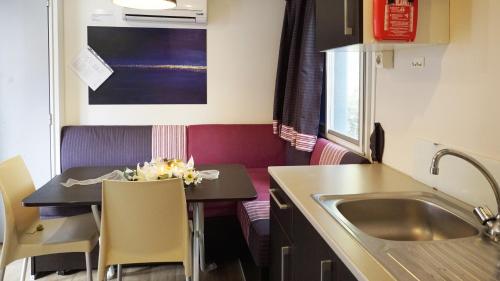a small kitchen with a table and a sink at Camping Village Adriatico Giulianova in Giulianova