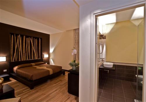 a bedroom with a bed and a bathroom with a shower at Design Suite Tirano in Tirano