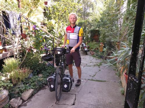 a man standing next to a bike in a garden at Base for Adventurers - Urban Guerrilla in Negotin