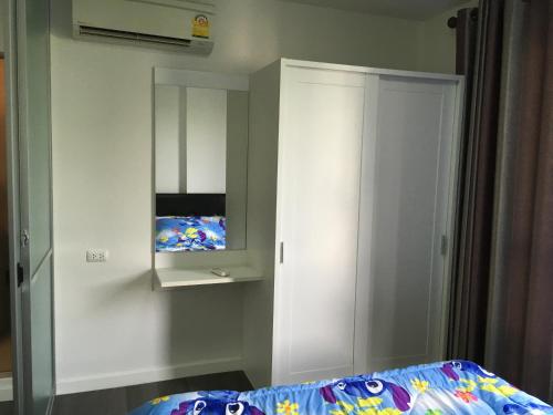 a bedroom with a white cabinet and a bed at D Condo Nernpra Rayong in Rayong