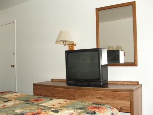 a television sitting on top of a dresser with a mirror at Arizona Inn in Kingman