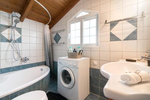 a bathroom with a washing machine and a sink at Villa Ismini in Zakynthos Town