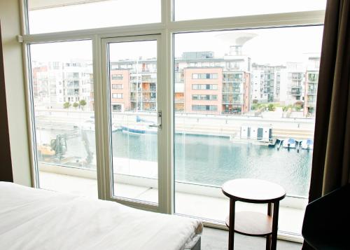 a bedroom with a large window with a view of the water at Hotel Öresund Conference & Spa in Landskrona