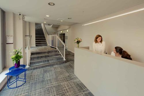 two women standing at a counter in a hallway at PREMIER SUITES Reading in Reading