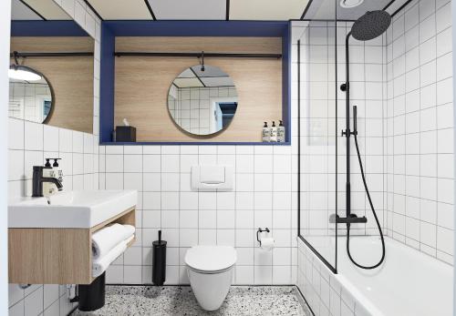 y baño con aseo, lavabo y ducha. en CPH Hotel, en Copenhague