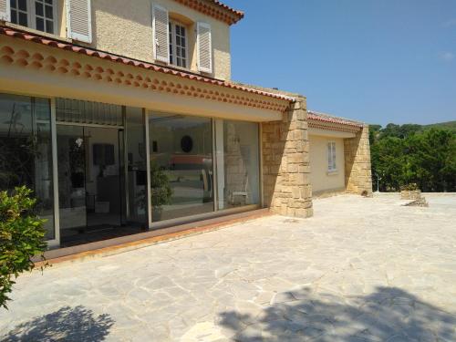 a house with sliding glass doors on a patio at Hôtel Castel Saint Anne in Le Castellet