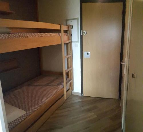 a small room with two bunk beds and a door at Le Champame in Mont-de-Lans