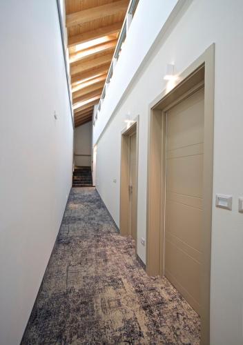 a corridor of an office building with doors and a carpet at Lifestyle Room Binario Zero in Tirano