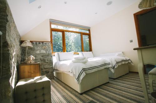 a bedroom with two beds and a window at Pencoed House Estate (Cardiff) in Cardiff