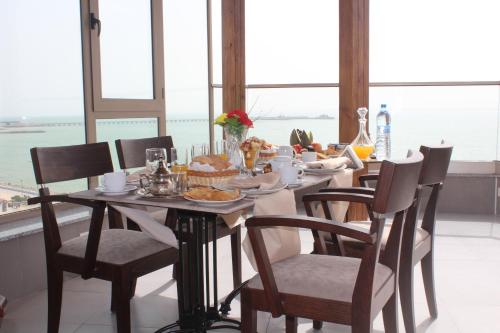 - une table avec des chaises et une table avec de la nourriture dans l'établissement Dakhla Sur Mer Hôtel, à Dakhla