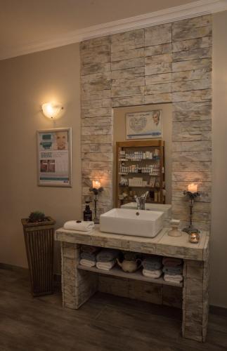 a bathroom with a sink and a stone wall at Island Cottage Guesthouse in Lüderitz