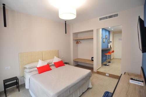 1 dormitorio con cama blanca y almohadas rojas en Delco Naples, en Nápoles