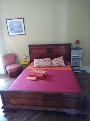 a bedroom with a large wooden bed with red sheets at Acropolis Apartment in Athens