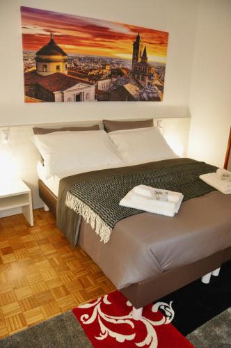 a bedroom with a bed with a painting on the wall at CityWalls Guest House Bergamo in Bergamo