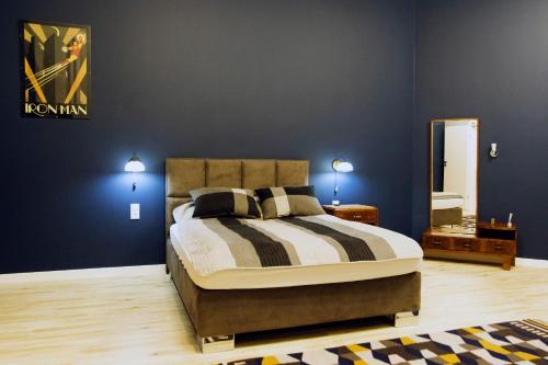 a bedroom with a bed with blue walls and a mirror at Art Deco/Vintage Apartments in Wrocław