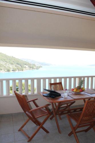 a table and chairs on a balcony with a view of the ocean at Villa Marija in Marina