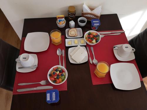 a table topped with white plates and bowls of food at Hostal del Valle in Santa Cruz