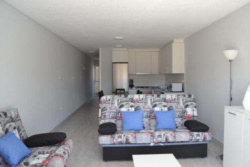 a living room with a couch and blue pillows at PRECIOSO APARTATAMENTO JUNTO AL MAR in Peñíscola